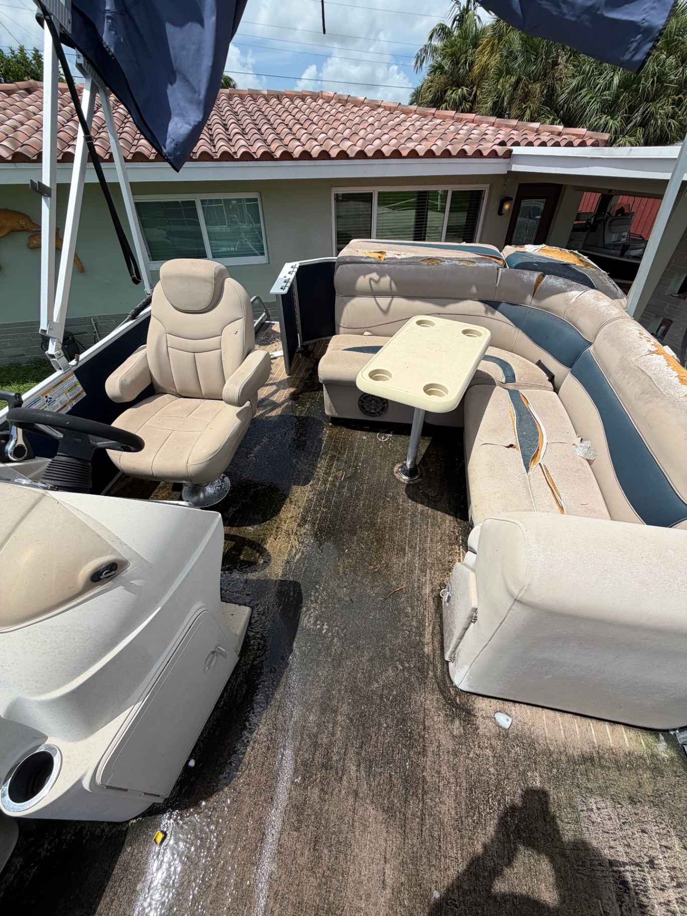 Pontoon helm seat and furniture showing sun damage and torn upholstery before repair
