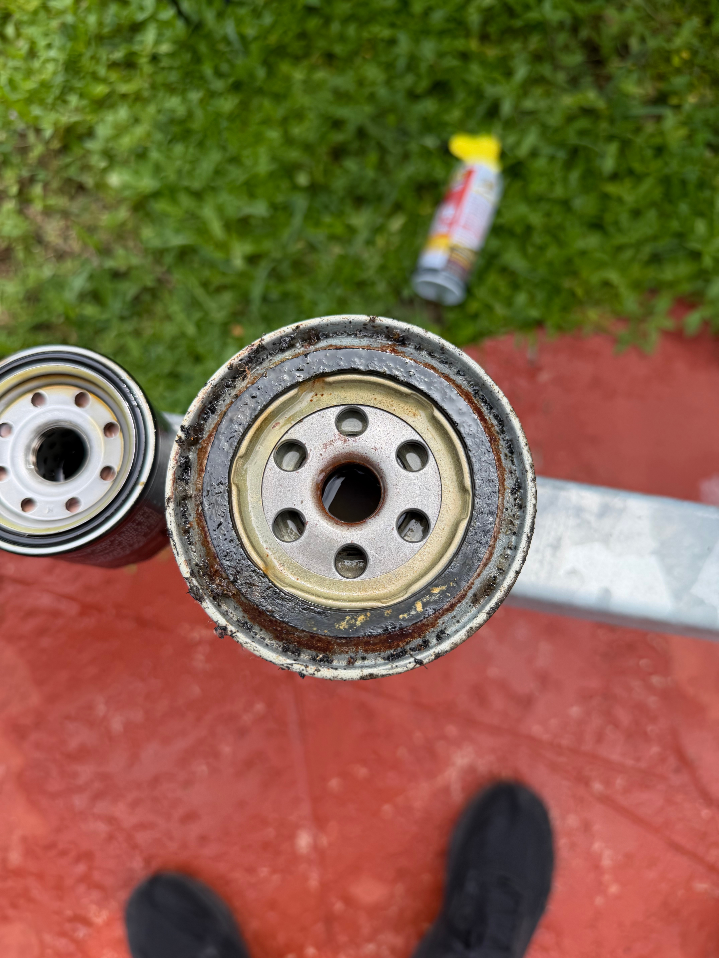 Used marine oil filter caked in burnt oil next to a clean replacement filter