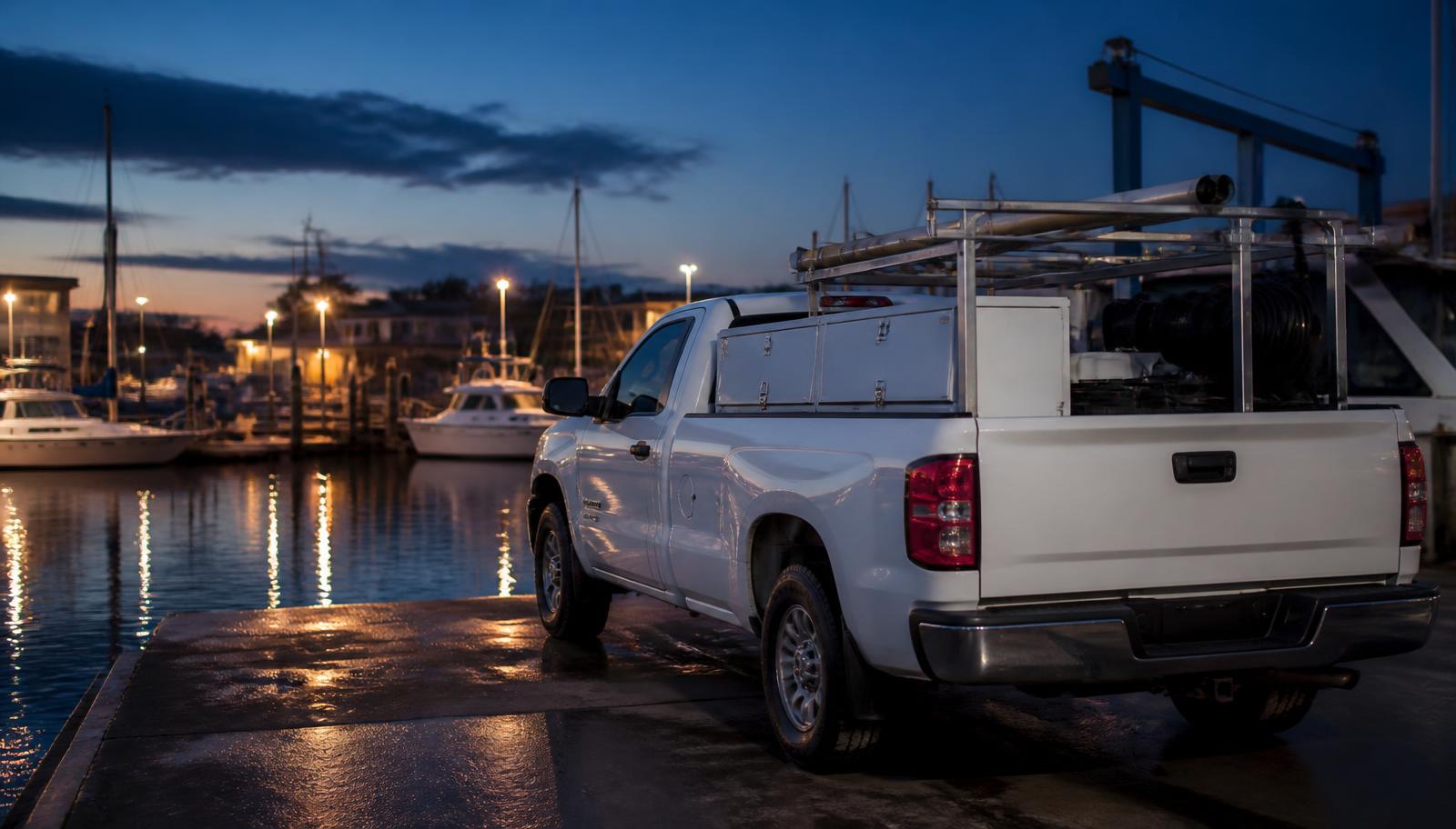 Mobile marine service truck parked at a marina at dusk